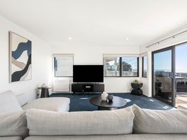 A living room with a couch and television at Sunbrae Sands - Mount Maunganui Holiday Homes, Mount Maunganui