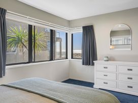 A bedroom with a bed and dresser at Sunbrae Sands - Mount Maunganui