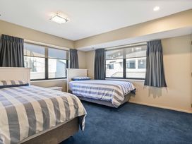 A bedroom with two beds and windows at Sunbrae Sands - Mount Maunganui