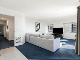 A living room with a sofa and television at Sunbrae Sands - Mount Maunganui Holiday Homes