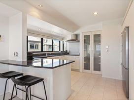 A kitchen with a counter and stools at Sunbrae Sands - Mount Maunganui Holiday Homes Mount Maunganui
