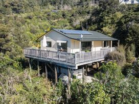 A house with a deck and solar panels at Tepuia Cottage - Havelock Holiday Retreat Marlborough