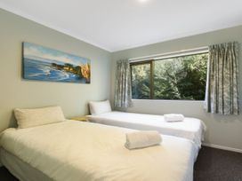 A bedroom with two beds and a window at Tepuia Cottage - Havelock Holiday Retreat Marlborough