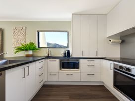 A kitchen with a sink, cabinets, microwave, and oven at Tepuia Cottage - Havelock Holiday Retreat, Marlborough