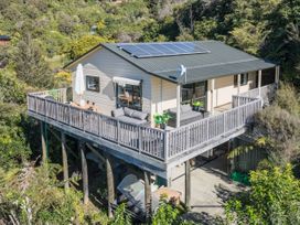 A house with a deck and solar panels at Tepuia Cottage - Havelock Holiday Retreat Marlborough