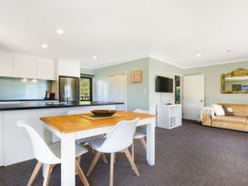A kitchen with a table and chairs and a living room area at Tepuia Cottage - Havelock Holiday Retreat Marlborough