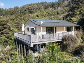 A house with a deck and solar panels at Tepuia Cottage - Havelock Holiday Retreat Marlborough