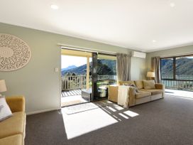 A living room with a sofa and a view of the mountains at Tepuia Cottage - Havelock Holiday Retreat Marlborough