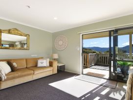 A living room with a sofa and sliding door at Tepuia Cottage - Havelock Holiday Retreat in Marlborough