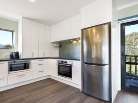 A kitchen with refrigerator and microwave at Tepuia Cottage - Havelock Holiday Retreat Marlborough