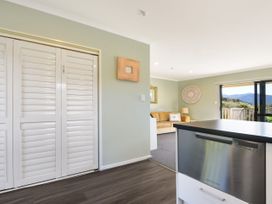 A kitchen with sliding doors and a dishwasher at Tepuia Cottage - Havelock Holiday Retreat Marlborough