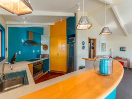 A kitchen with a blue and yellow color scheme at Rainbow Point Yacht Club - Taupo