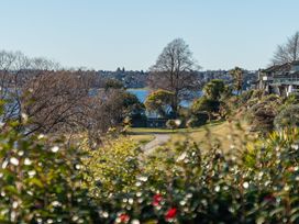 A view of a lake with trees and houses at Rainbow Point Yacht Club - Taupo