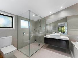 A bathroom with a shower, sink, and toilet at Rainbow Point Yacht Club - Taupo Holiday Home Taupo