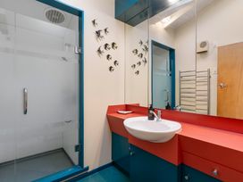 A bathroom with a mirror, sink, and shower at Rainbow Point Yacht Club - Taupo