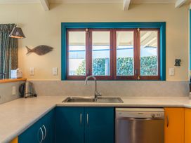 A kitchen with a sink and dishwasher at Rainbow Point Yacht Club - Taupo Holiday Home, Taupo