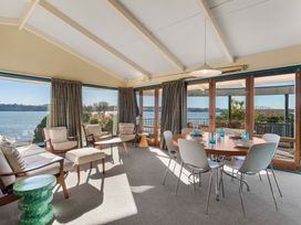 A living room with a dining table and chairs at Rainbow Point Yacht Club - Taupo Holiday Home