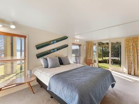 A bedroom with a bed and skis on the wall at Rainbow Point Yacht Club - Taupo
