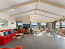 A living room with a sofa and dining area at Rainbow Point Yacht Club - Taupo Holiday Home, Taupo