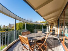 An outdoor dining area with a table and chairs at Rainbow Point Yacht Club - Taupo Holiday Home Taupo
