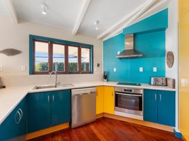 A kitchen with a sink, oven, and window at Rainbow Point Yacht Club - Taupo