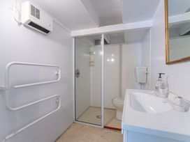 A bathroom with a shower, toilet, and sink at Rainbow Point Yacht Club - Taupo Holiday Home, Taupo