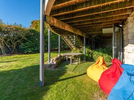 An outdoor area with a table and bean bags at Rainbow Point Yacht Club - Taupo Holiday Home in Taupo