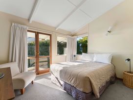 A bedroom with a bed and window at Rainbow Point Yacht Club - Taupo Holiday Home Taupo