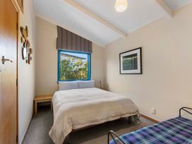 A bedroom with a bed and a nightstand at Rainbow Point Yacht Club - Taupo