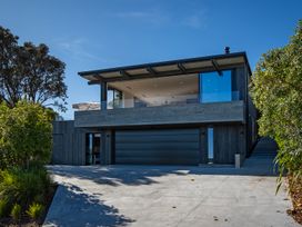 A house with a garage and exterior landscaping at Langs Beach Holiday Home in Langs Beach