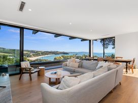 A living room with a sofa, coffee table, and dining area at Langs Beach Holiday Home in Langs Beach