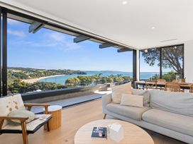 A living room with a view of the water and seating area at Langs Beach Holiday Home in Langs Beach