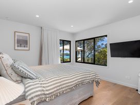 A bedroom with a bed and windows at Langs Beach Holiday Home in Langs Beach