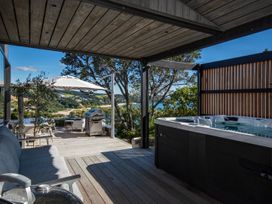 An outdoor area with a hot tub and grill at Langs Beach Holiday Home in Langs Beach