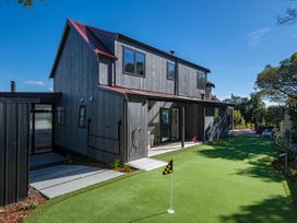 An outdoor area featuring a house and a golf putting green at Langs Beach Holiday Home in Langs Beach
