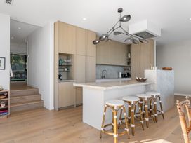 A kitchen with an island and stools at Langs Beach Holiday Home Langs Beach