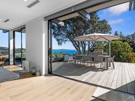 A living room opening to a deck with outdoor dining furniture at Langs Beach Holiday Home in Langs Beach