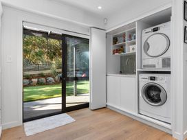 A laundry room with appliances and a door leading outside at Langs Beach Holiday Home in Langs Beach