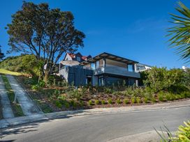 A house with trees and plants on a slope at Langs Beach Holiday Home in Langs Beach