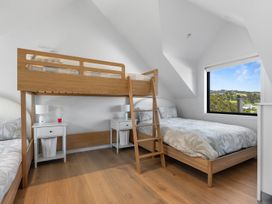 A bedroom with a bunk bed and a single bed at Langs Beach Holiday Home Langs Beach