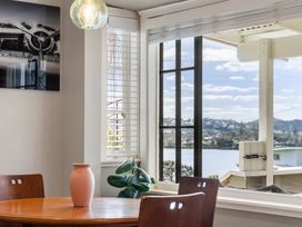 A dining room with a table, vase, and plant at Rockstar Retreat - Auckland Holiday Home, Red Beach
