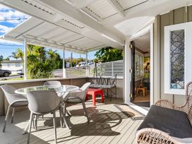 An outdoor area with a table and chairs at Rockstar Retreat - Auckland Holiday Home, Red Beach