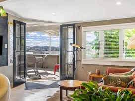 A living room with a telescope and plants at Rockstar Retreat - Auckland Holiday Home in Red Beach