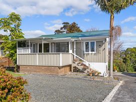 A house with a front porch and steps at Rockstar Retreat - Auckland Holiday Home Red Beach