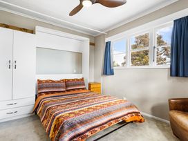 A bedroom with a bed and nightstand at Rockstar Retreat - Auckland Holiday Home Red Beach