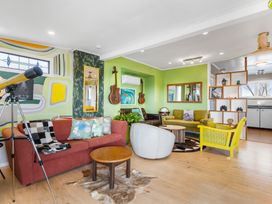 A living room with a telescope and seating arrangements at Rockstar Retreat - Auckland Holiday Home in Red Beach