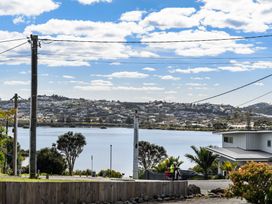 A view of water and houses at Rockstar Retreat - Auckland Holiday Home Red Beach