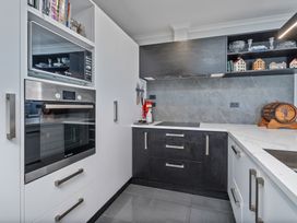 A kitchen with an oven and microwave at Endeavour Oasis - Whitianga Holiday Home in Whitianga