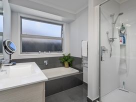 A bathroom with a bathtub and shower at Endeavour Oasis - Whitianga Holiday Home, Whitianga