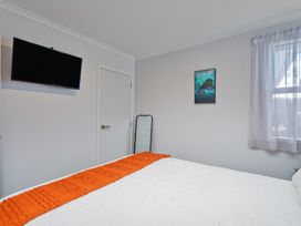 A bedroom with a bed and television at Endeavour Oasis - Whitianga Holiday Home in Whitianga
